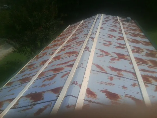 Rusted metal roof panels with new wood purlins before replacement — Storm Damage Roof Repair in Hurdle Mills by Roofing Brothers